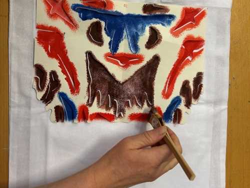 Hånd som maler med pensel på en totebag.