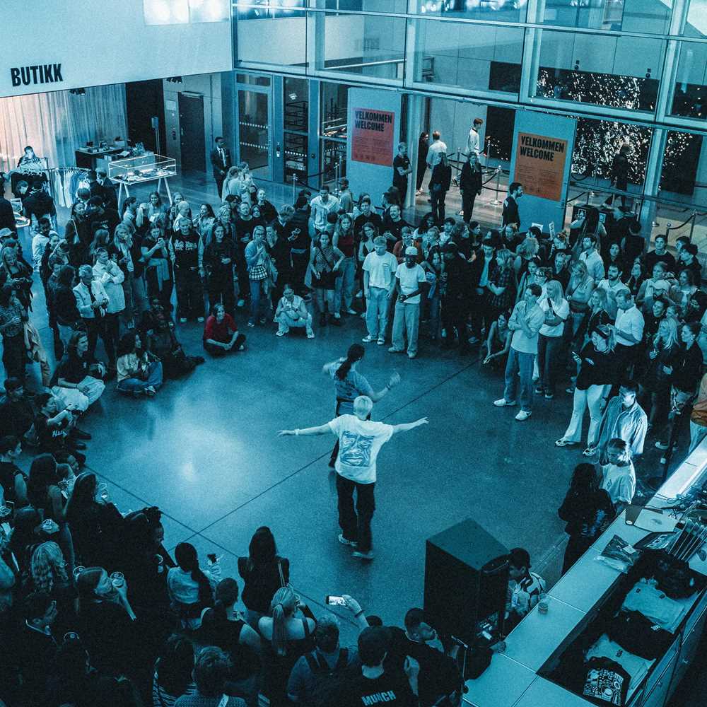 Foto fra lobby av dansende mennesker omringet av stående publikum.