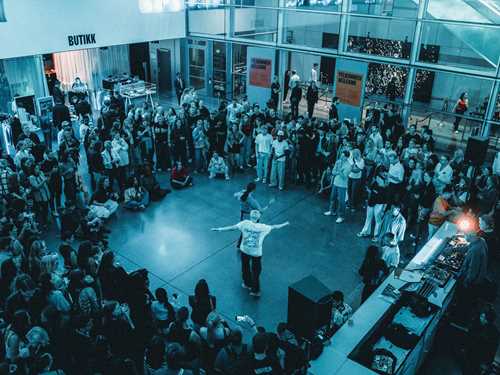 Foto fra lobby av dansende mennesker omringet av stående publikum.
