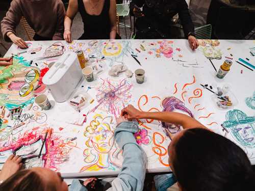 Bord under verksted med mange mennesker.