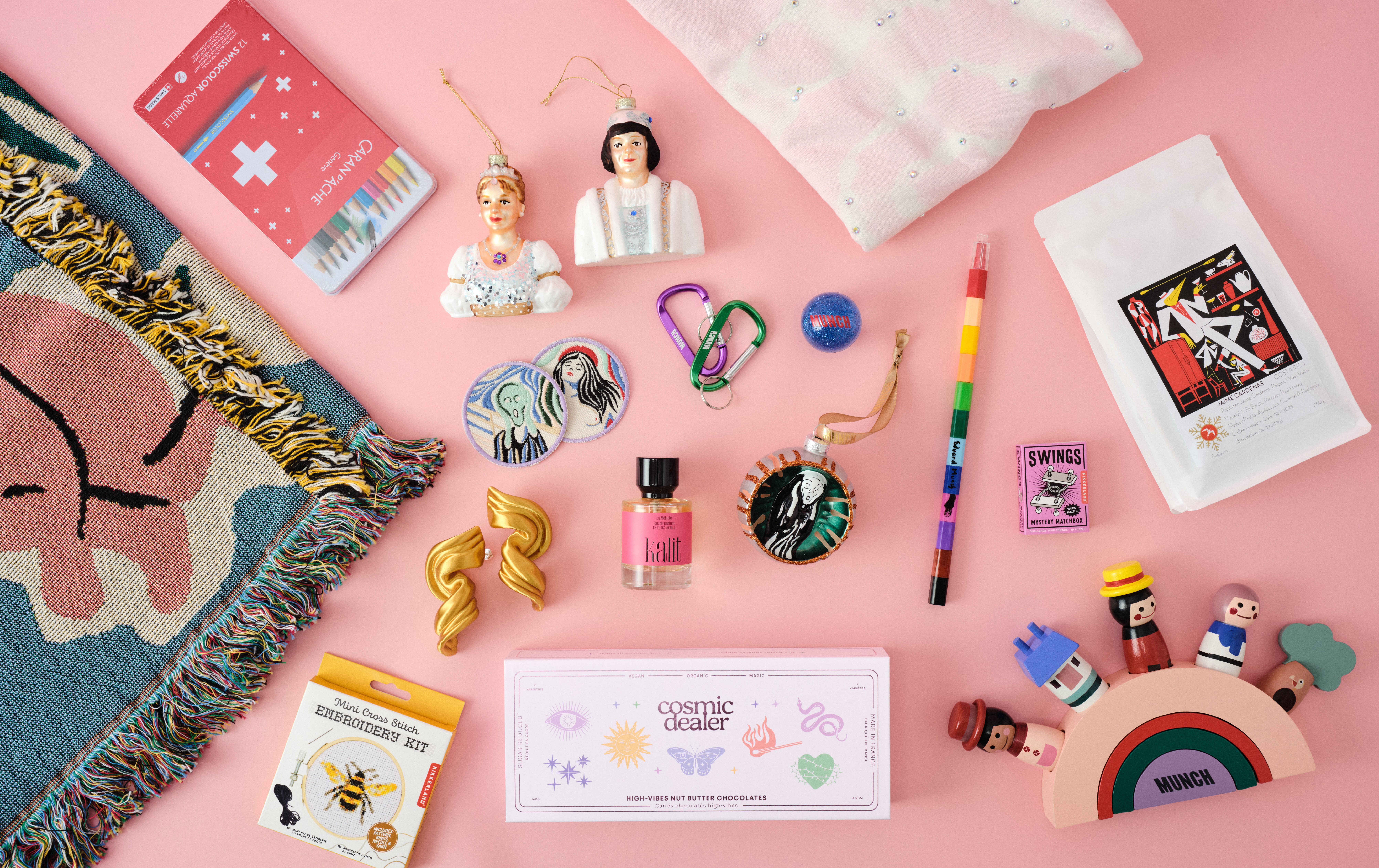 Et utvalg av produktene i MUNCHs butikk. Julekuler formet som Askepott og prinsen, fargestifter, en julekule med Skrik, øredobber, parfyme, en t-skjorte med glitrende steiner, en treleke for barn og en pose med kaffe. Fotografi