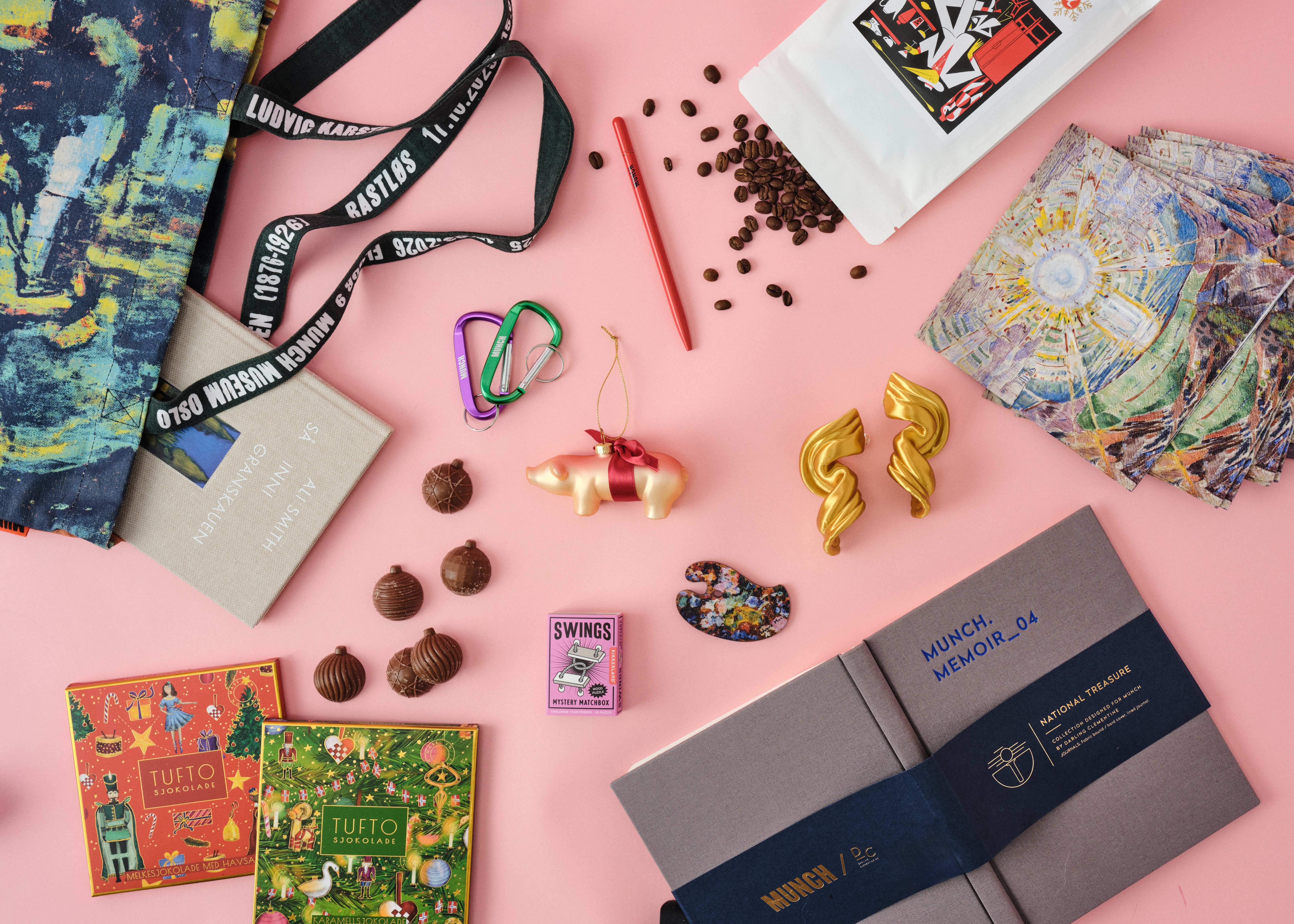 Et utvalg av produkter du finner i MUNCHs butikk og nettbutikk denne julen. Varer som kaffebønner, sjokolade, notatbøker, karabinkroker, øredobber og bærenett. Fotografi