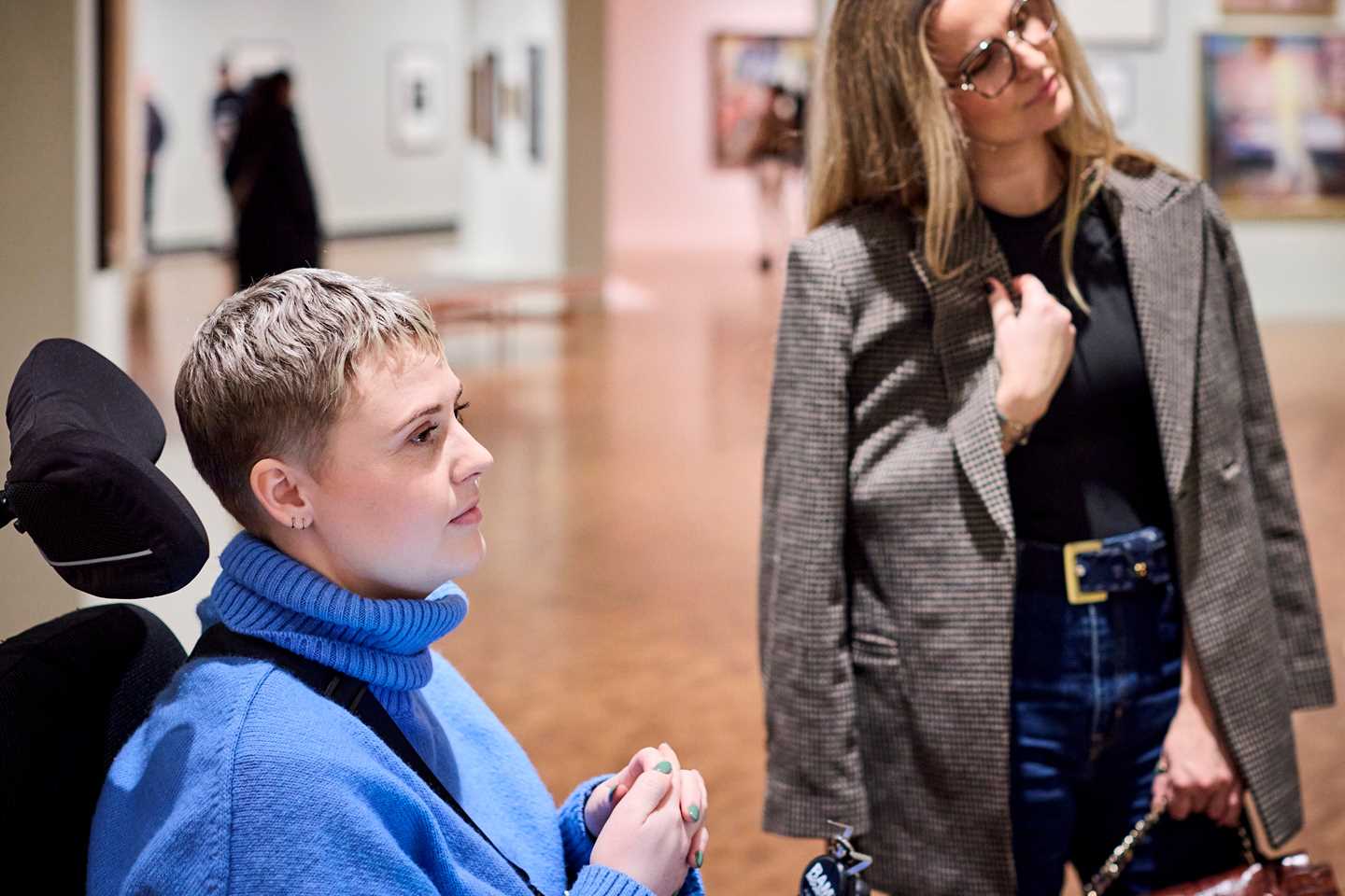 To kvinner står og betrakter et kunstverk i utstillingen Uendelig. Fotografi