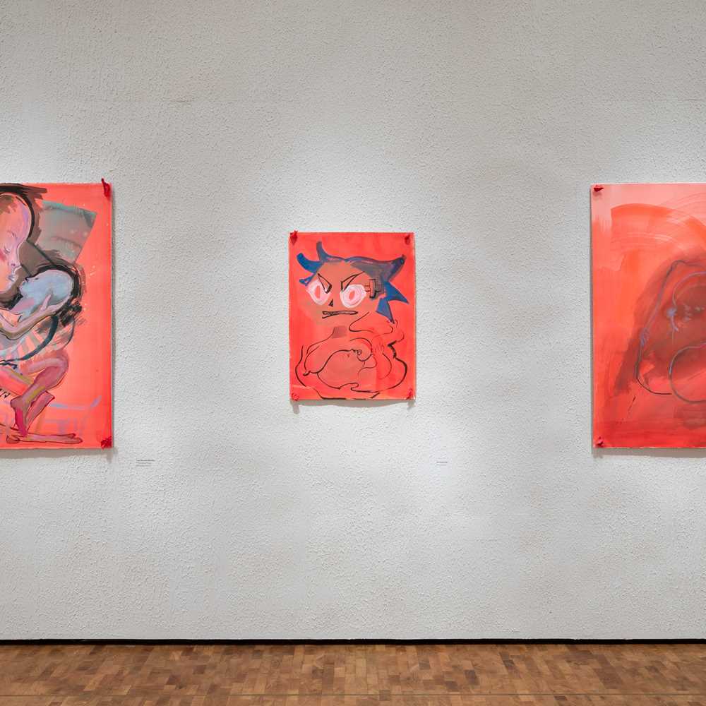 Installasjonsbilde fra utstillingen CAMILLE HENROT – MUNN TIL MUNN. Tre røde kunstverk uten rammer montert på en betongaktig vegg.