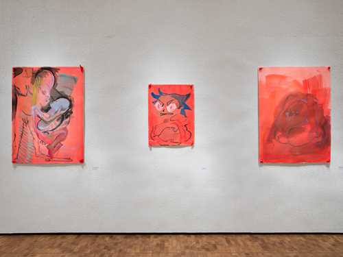 Installasjonsbilde fra utstillingen CAMILLE HENROT – MUNN TIL MUNN. Tre røde kunstverk uten rammer montert på en betongaktig vegg.