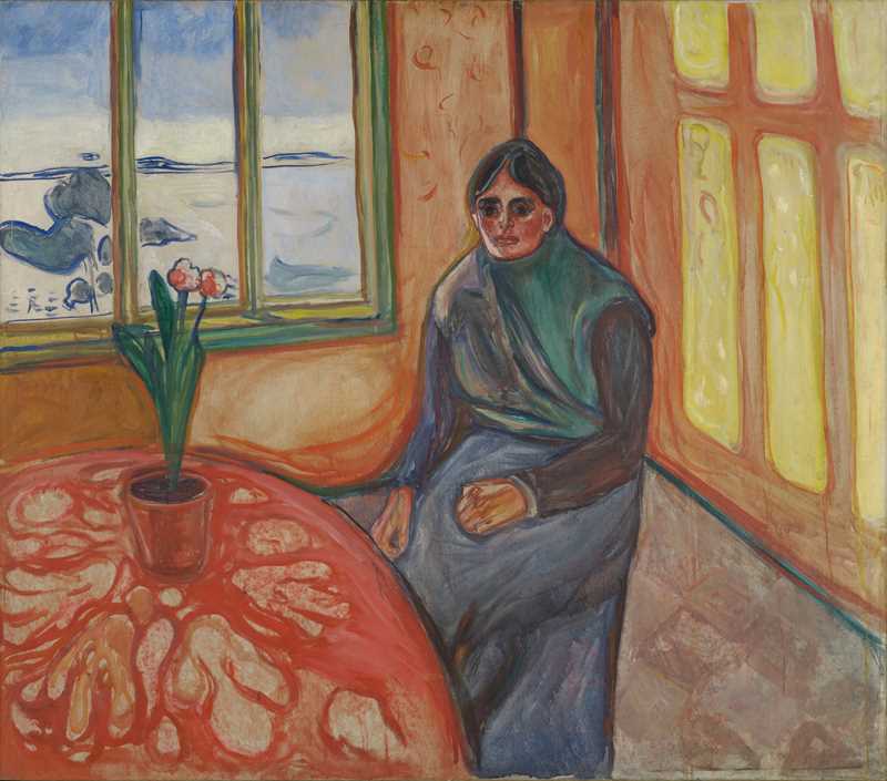 Kvinne i mørke klær sitter i et oransjfarget rom ved et rødt bord med blomstervase. Bak henne er et åpent vindu med utsikt mot sjøen.
