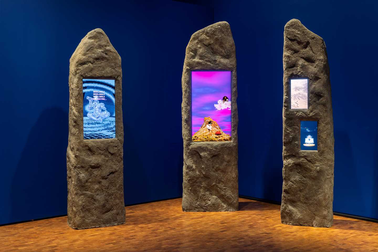 Tre kampesteiner har innfeldte skjermer som viser forskjellige klipp i sterke farger. Fotografi