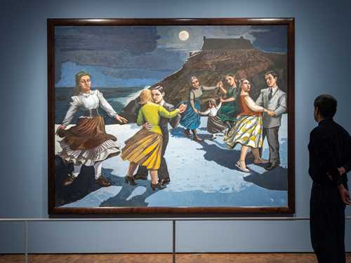 En mann står med ryggen mot kamera og betrakter verket Dansen av Paula Rego. Maleriet viser en strand med et fjell i bakgrunnen og en mørk himmel med en lysende måne. På stranden er det flere par som danser og en kvinne som danser alene. Fotografi