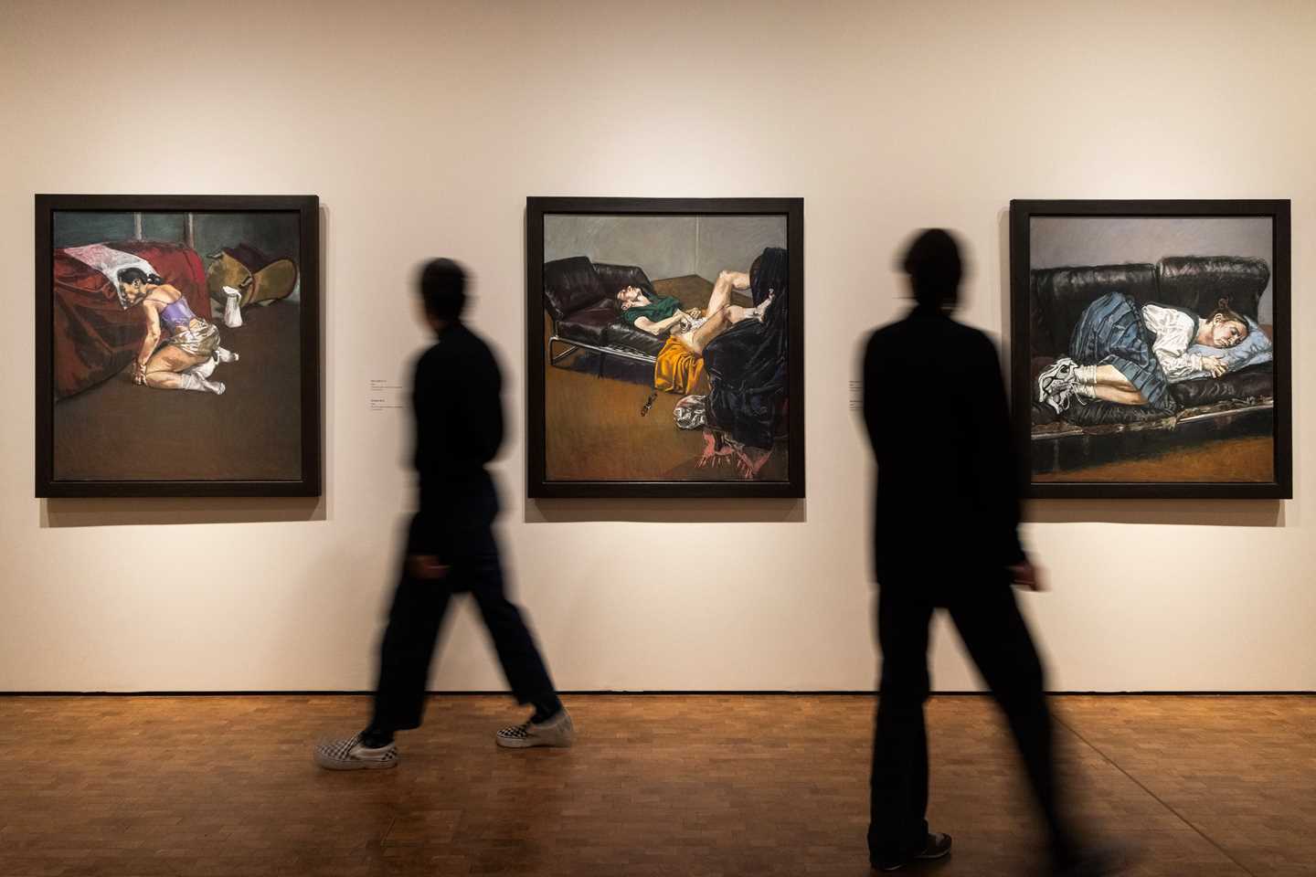 Bilde fra utstillingssal som viser verk av Paula Rego. I dette bildet er det tre verk fra Regos abortserie som henger på hvite vegger. To mennesker går gjennom salen. Fotografi
