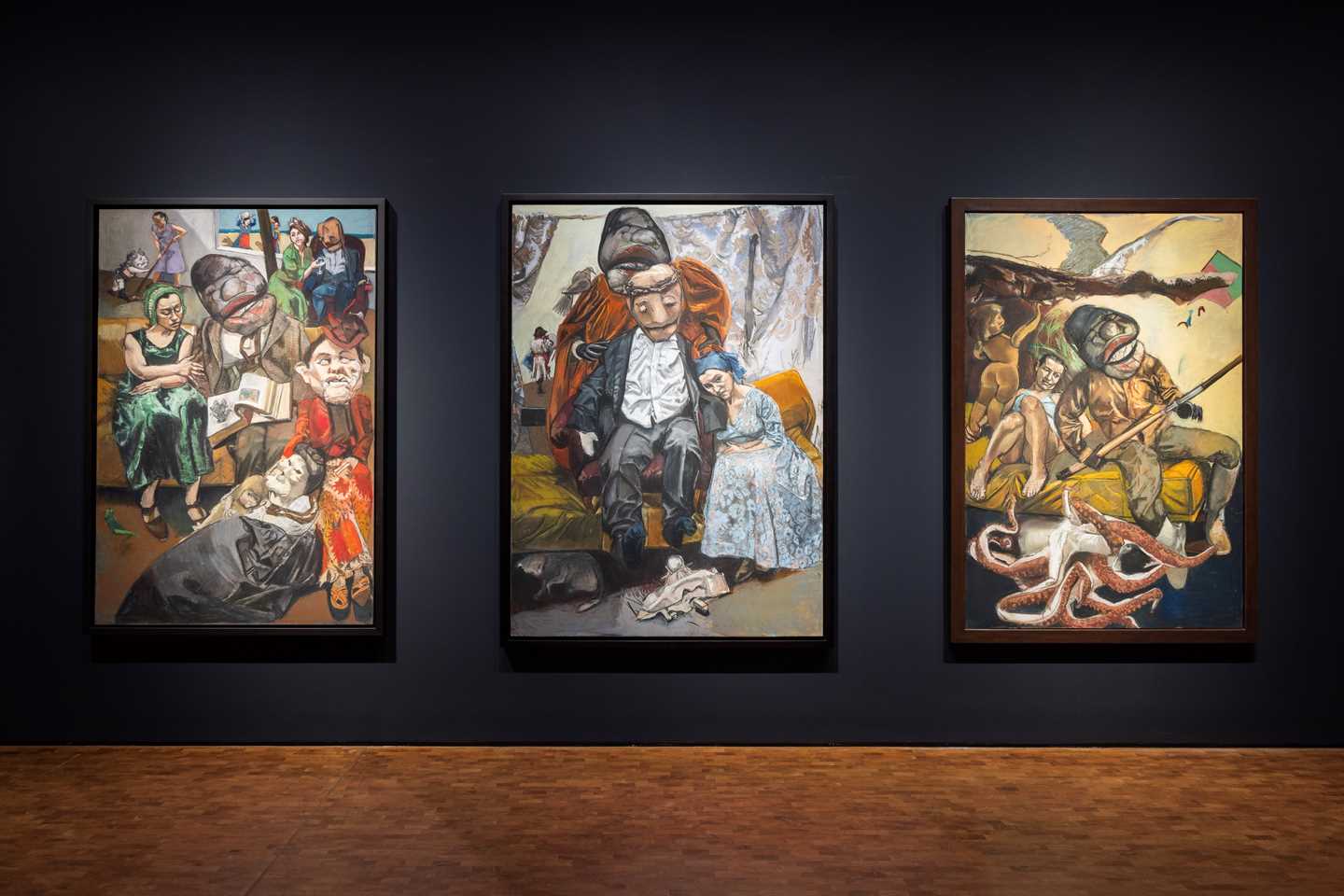 Tre pasteller av Paula Rego henger mot en dyp blå vegg. Fotografi