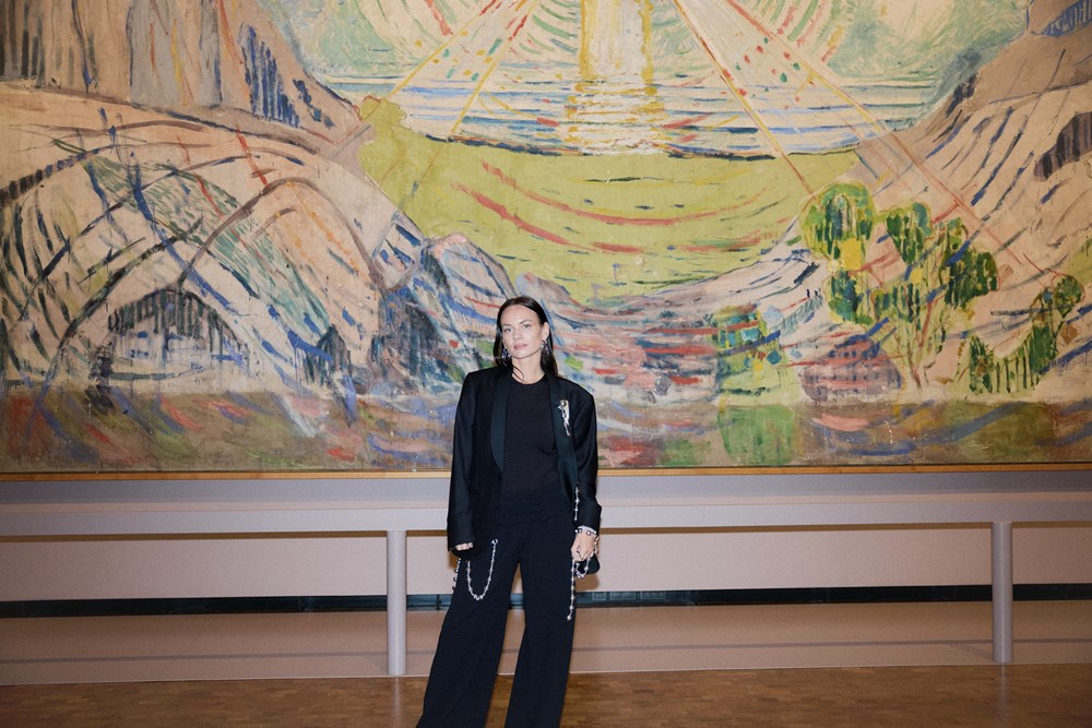 Motedesigner PearlOctopuss.y poserer foran maleriet Solen av Edvard Munch. Fotografi