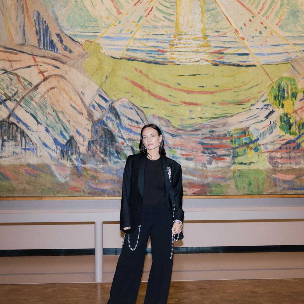 Motedesigner PearlOctopuss.y poserer foran maleriet Solen av Edvard Munch. Fotografi