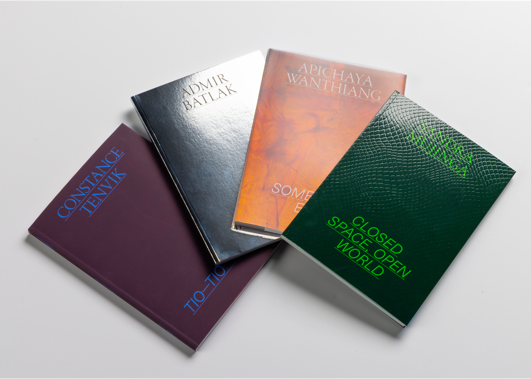 A photo of the four SOLO OSLO books. One in purple, one in silver, one in orange and one in green.